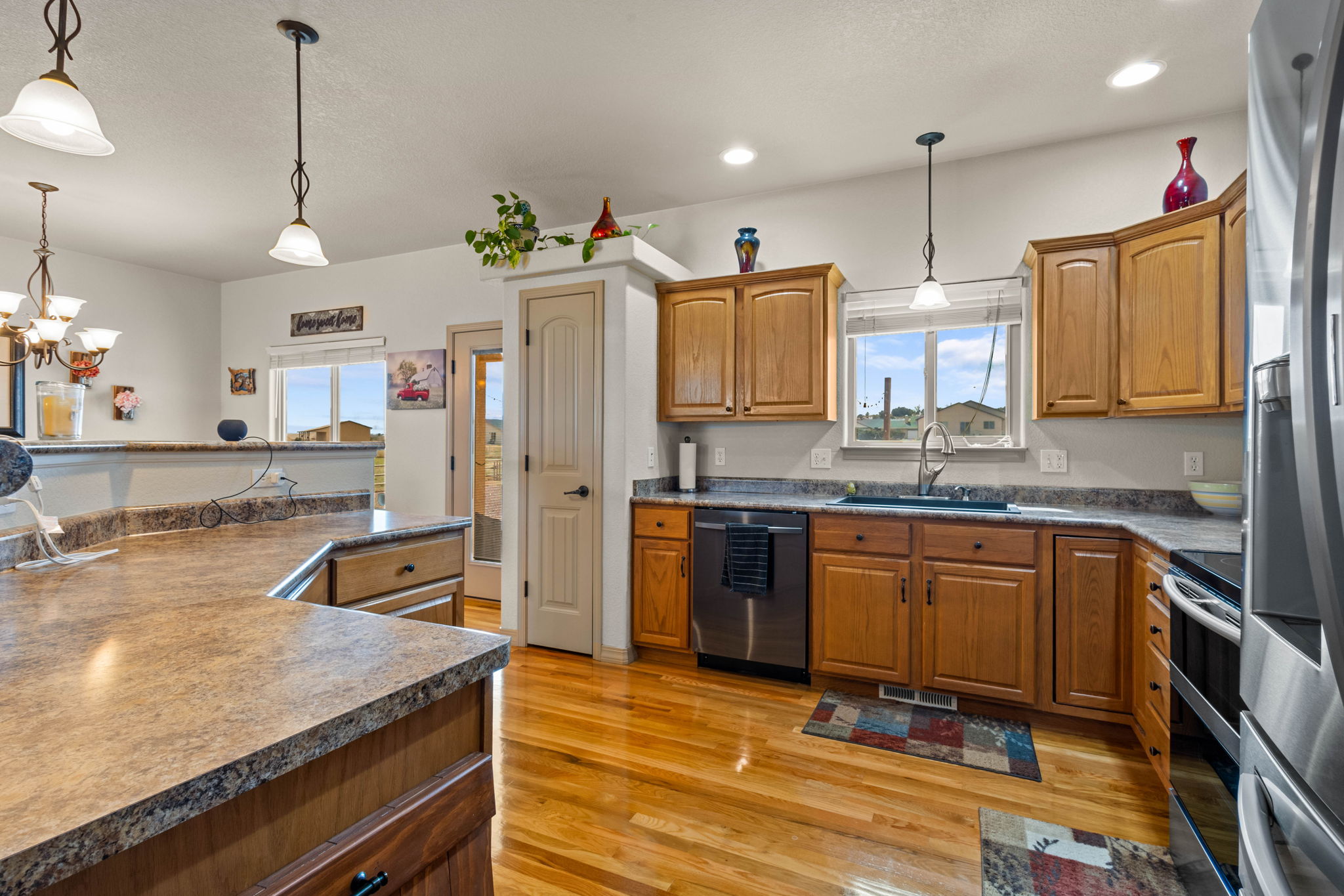Kitchen with gleaming hardwood floors, smooth top counters and pantry.