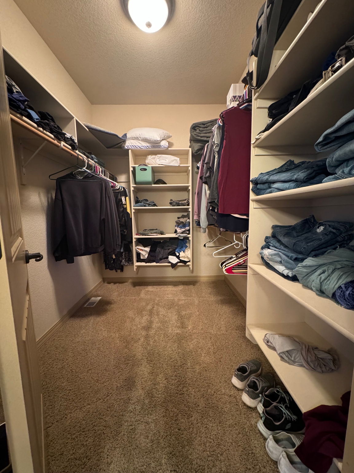 Primary Walk-in Closet with wood shelving