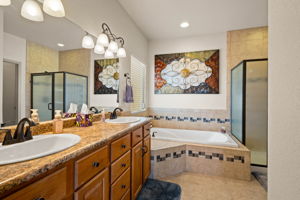 Primary spa-like bathroom with tile flooring.