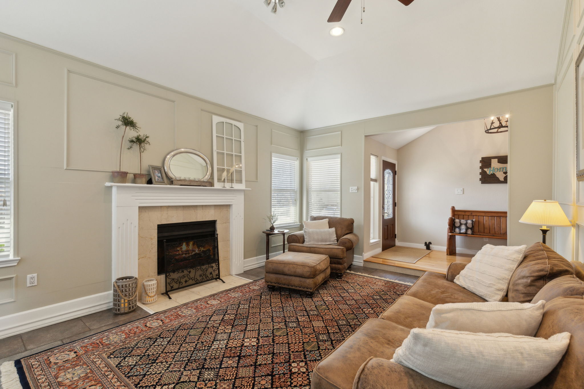 This spacious Main Living Area showcases the woodburning fireplace and lovely views from the multiple windows - lots of light and yet both warm and cozy!