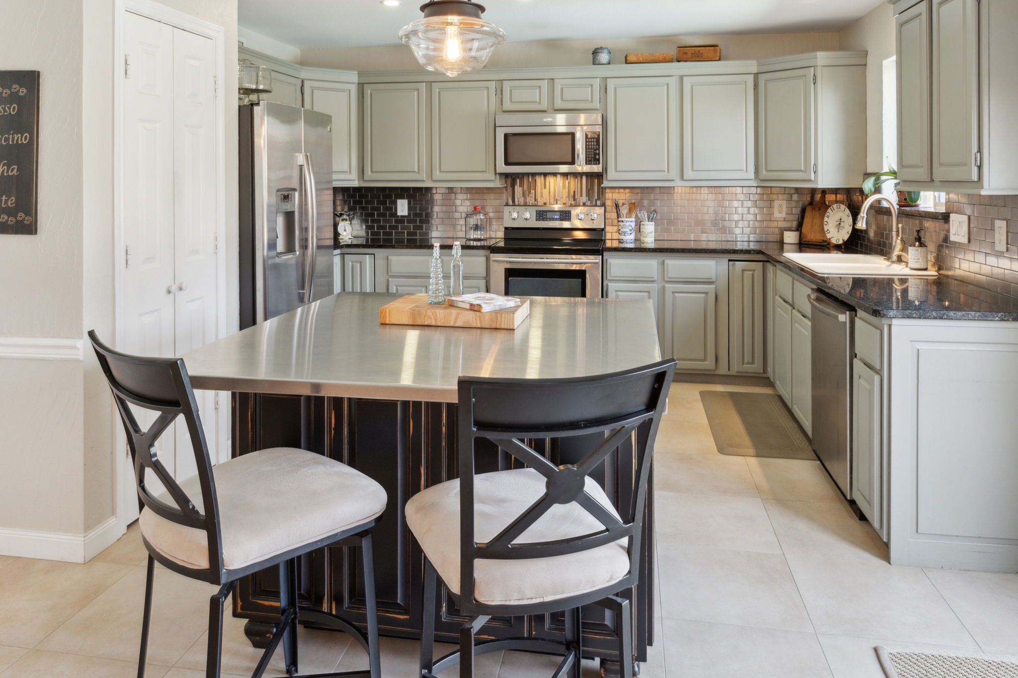 The Gourmet Kitchen is even more striking in person!  SS Appliances, granite counters, tasteful backsplash, loads of storage and the professionally designed island with SS counter top rounds out this one-of-a-kind kitchen!