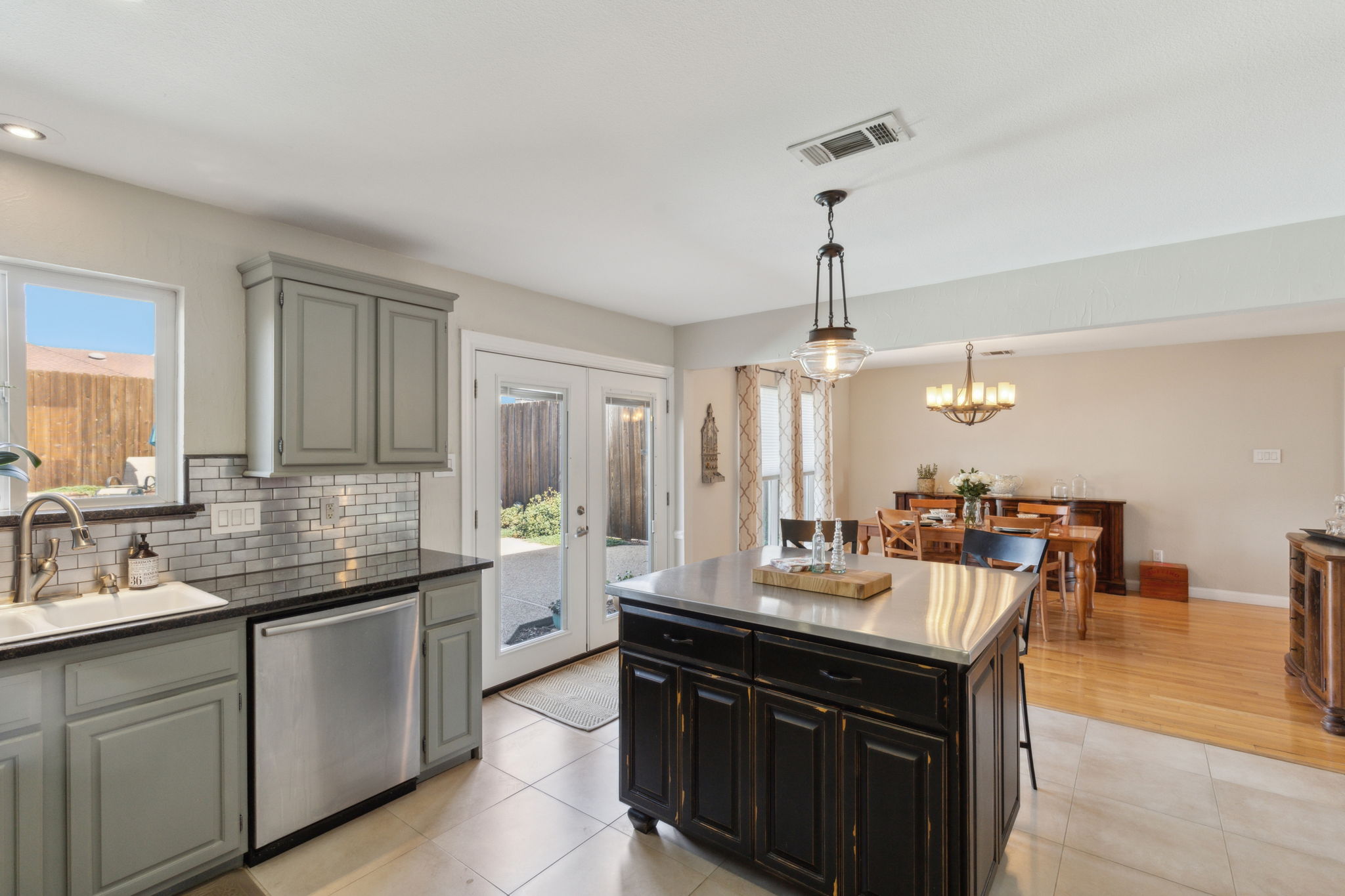 This view shows the open and spacious floorplan as well as the updated patio doors. Love the tasteful lighting over the island and in the dining area!