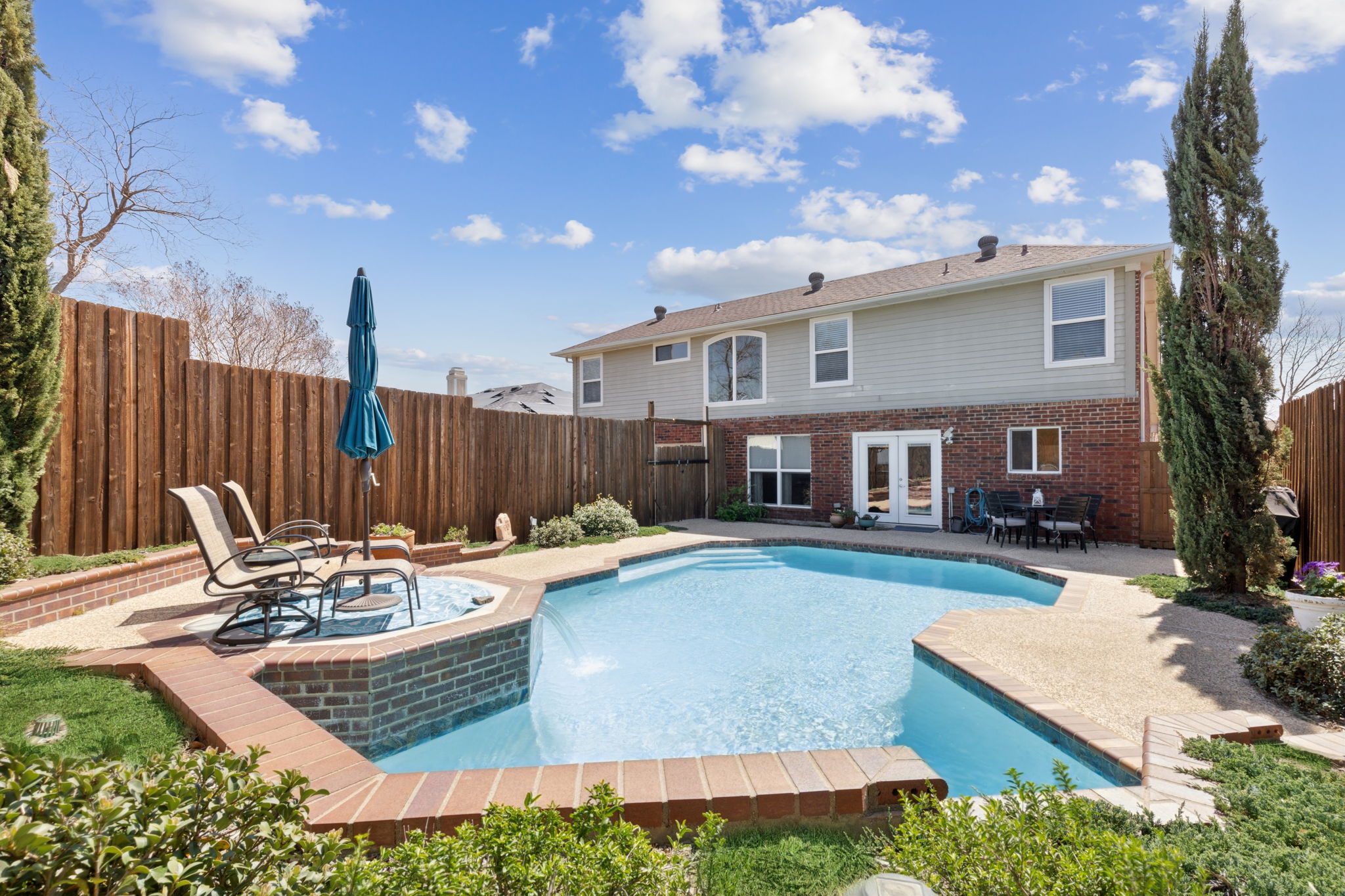 This view also shows the lovely view of the rear of the home - landscaping around the pool and just how big this pool area really is!!