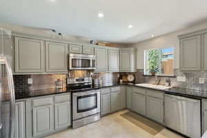 LOVE the warm color of the cabinets - and don't miss the view from the large kitchen window - attractive flooring too!