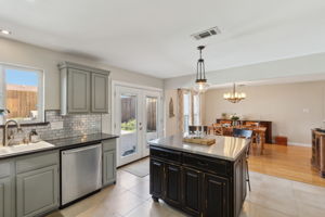 This view shows the open and spacious floorplan as well as the updated patio doors. Love the tasteful lighting over the island and in the dining area!