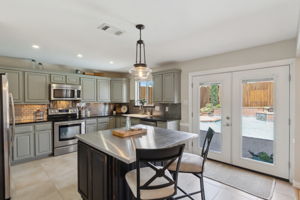 This "award winning" kitchen, with views of the backyard with the flowing waterfall and inviting deck area is stunning!