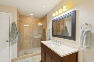 The beautifully updated spacious walk-in shower with frameless glass and charming tilework invites you to a relaxing and private master ensuite.