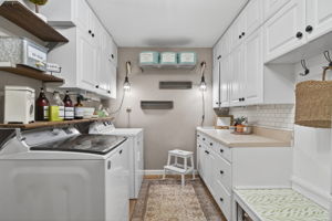 Functional and large laundry room with storage and direct access to garage.