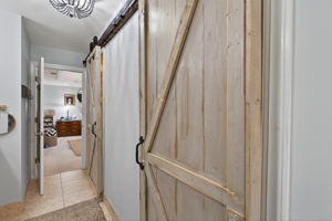 Barn doors open to double walk-in closets and serious style.