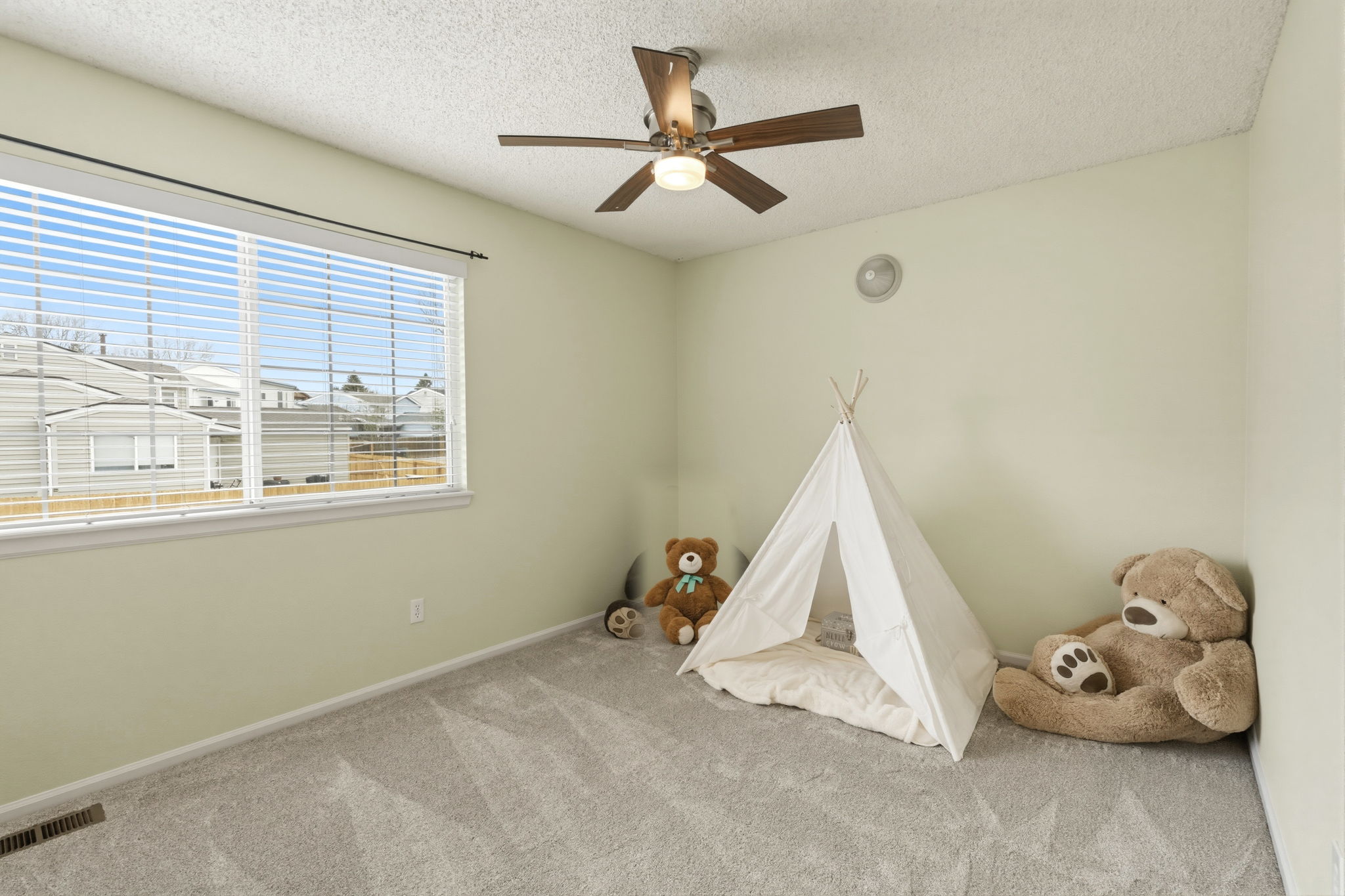 2nd bedroom with walk in closet and ceiling fan