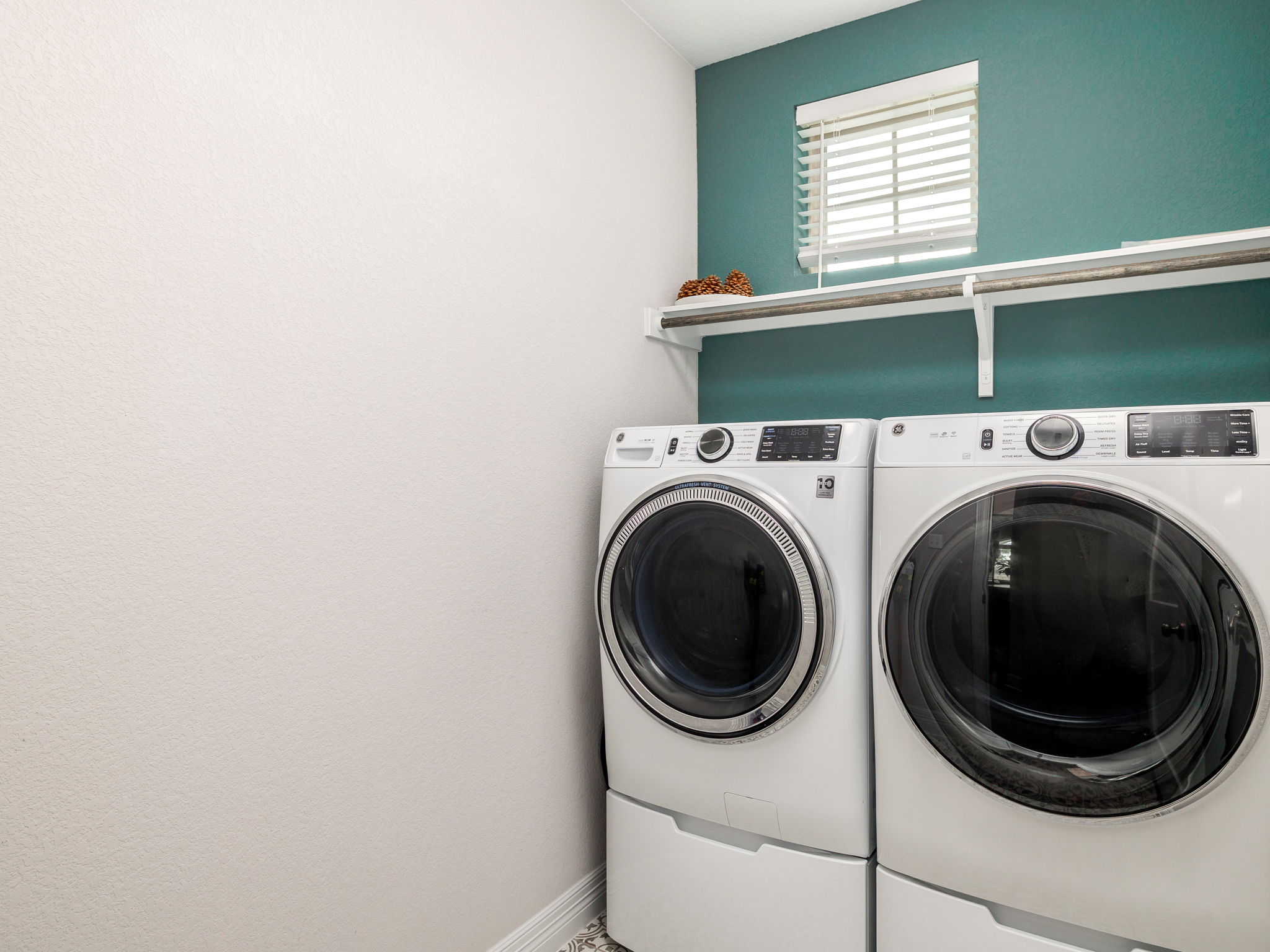The green accent wall and spanish tile flooring make the laundry room a fun place to pop into!
