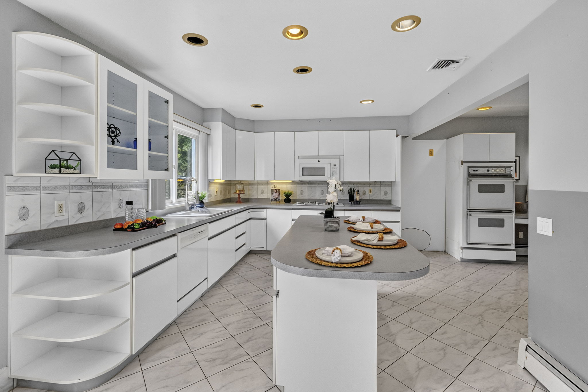 Eat in Kitchen: Designed for gathering, the eat-in kitchen features white lacquer cabinetry, a pantry, dedicated coffee bar and large center island with seating for up to six. A separate dining area provides additional seating and creates an easy flow between cooking, dining and entertaining.