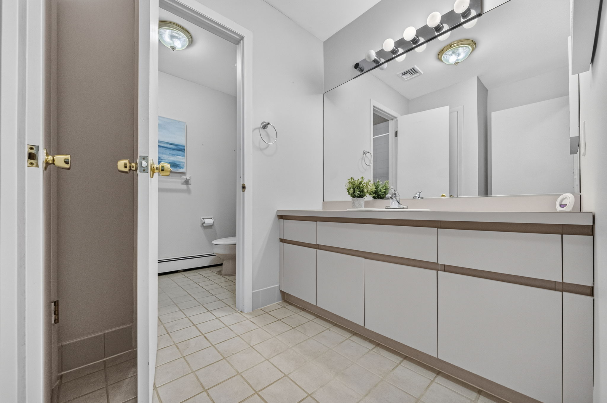 Second floor main bath featuring dual sinks and a separate shower and toilet area. A freshly painted second-floor laundry room keeps daily tasks conveniently close to the bedrooms.