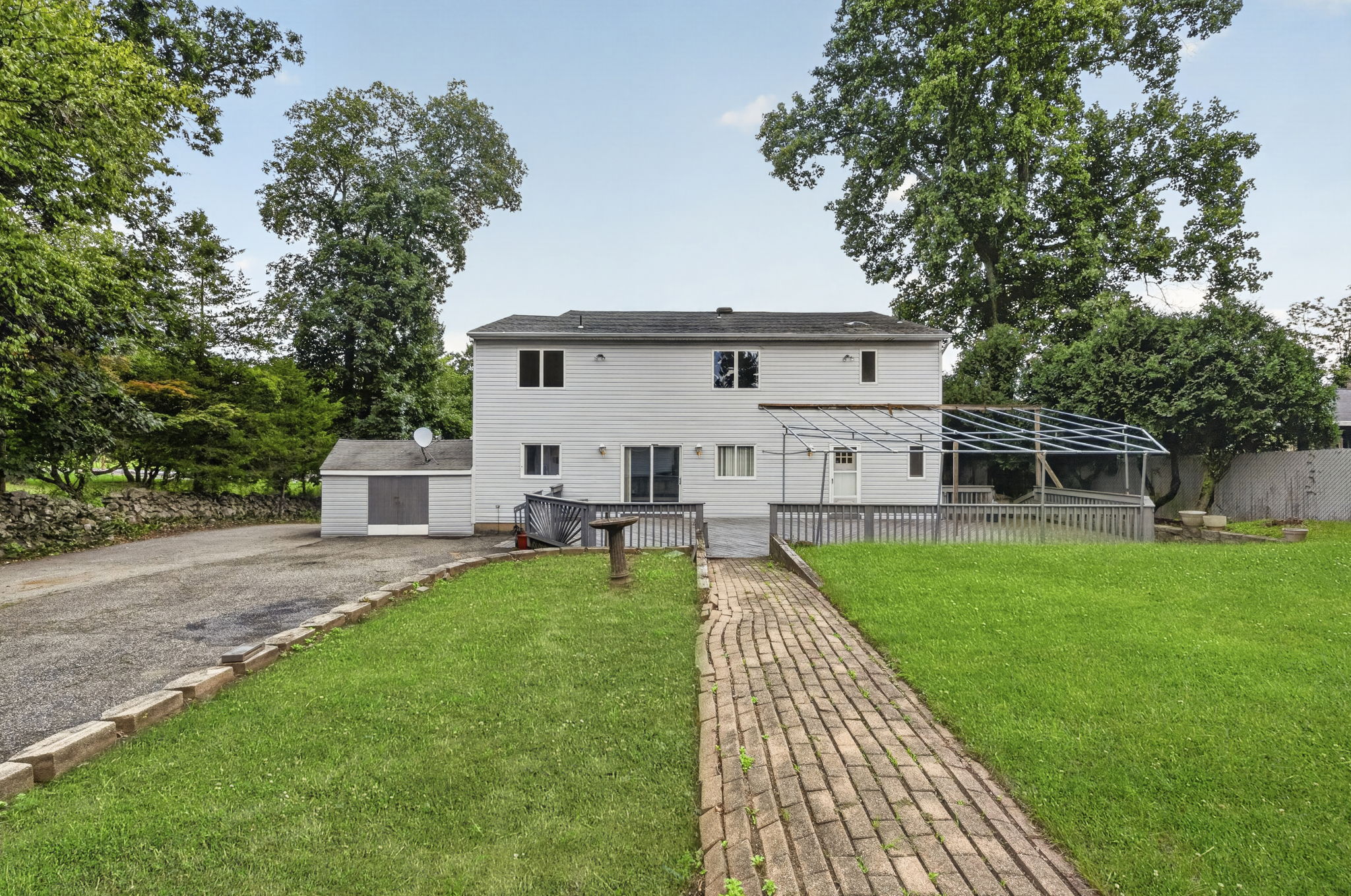 Step outside to an oversized wood deck overlooking the expansive backyard, larger than most at about 1 acre, , with an attached exterior shed providing additional storage.