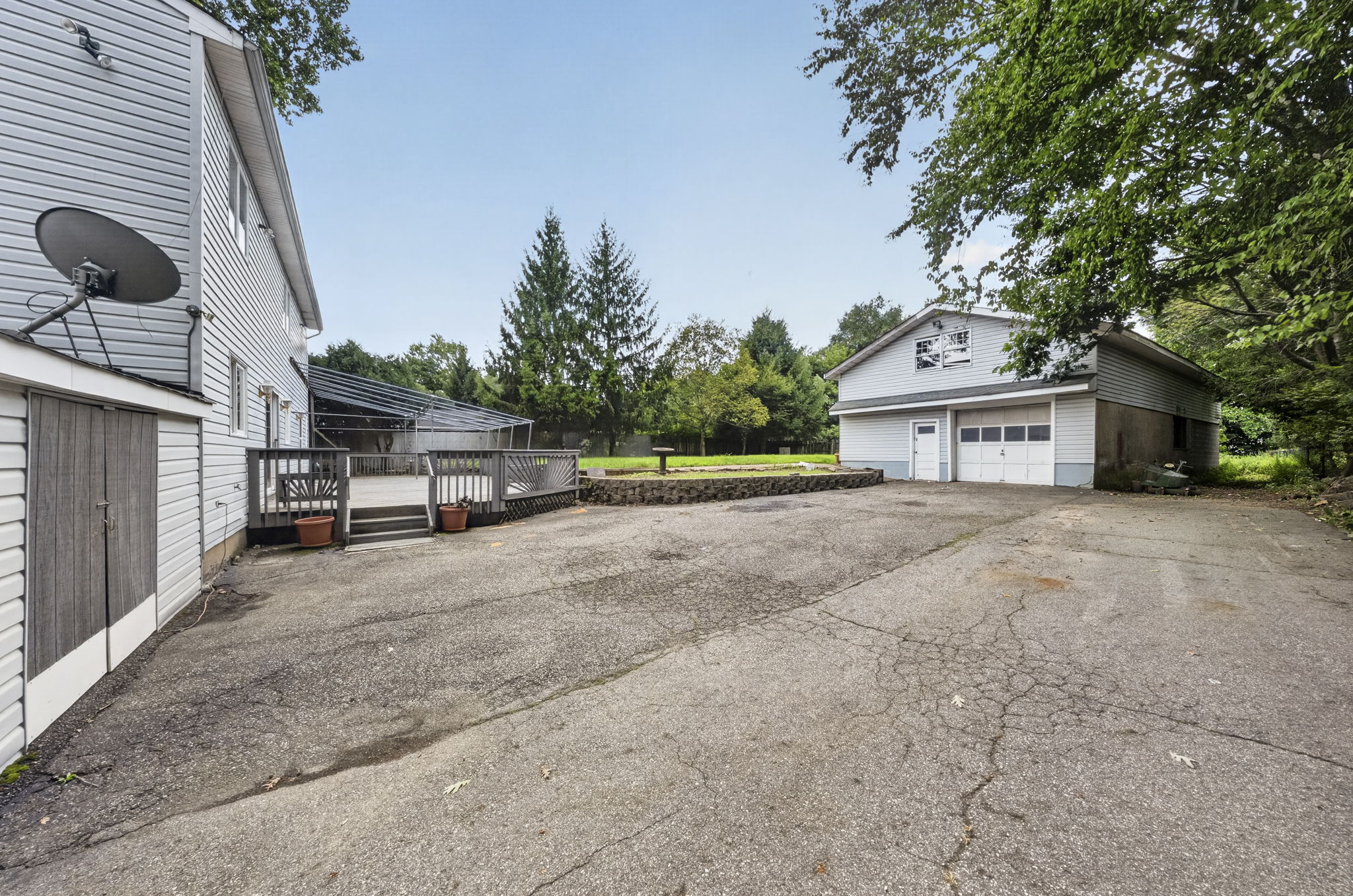 Step outside to an oversized wood deck overlooking the expansive backyard, with an attached exterior shed providing additional storage. One of the property’s most notable features is the detached tandem garage with a loft. Accommodating up to 5 cars, it also offers exceptional space for hobbies and storage. The oversized driveway provides plenty of additional parking.