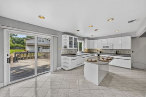 Eat in Kitchen: Designed for gathering, the eat-in kitchen features white lacquer cabinetry, a pantry, dedicated coffee bar and large center island with seating for up to six. A separate dining area provides additional seating and creates an easy flow between cooking, dining and entertaining.