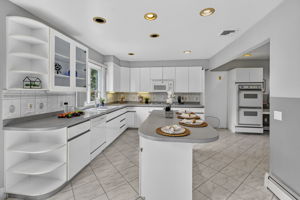 Eat in Kitchen: Designed for gathering, the eat-in kitchen features white lacquer cabinetry, a pantry, dedicated coffee bar and large center island with seating for up to six. A separate dining area provides additional seating and creates an easy flow between cooking, dining and entertaining.