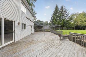 Step outside to an oversized wood deck overlooking the expansive backyard , larger than others, with almost one acre.