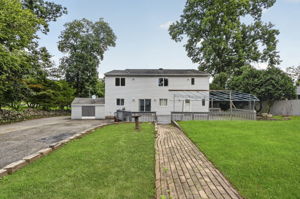 Step outside to an oversized wood deck overlooking the expansive backyard, larger than most at about 1 acre, , with an attached exterior shed providing additional storage.