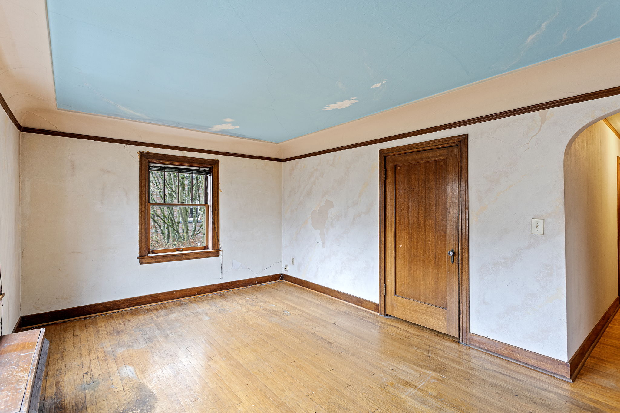 A welcoming space full of vintage charm—original mahogany trim, arched entryways, warm natural light, and a walk-in closet of its own.
