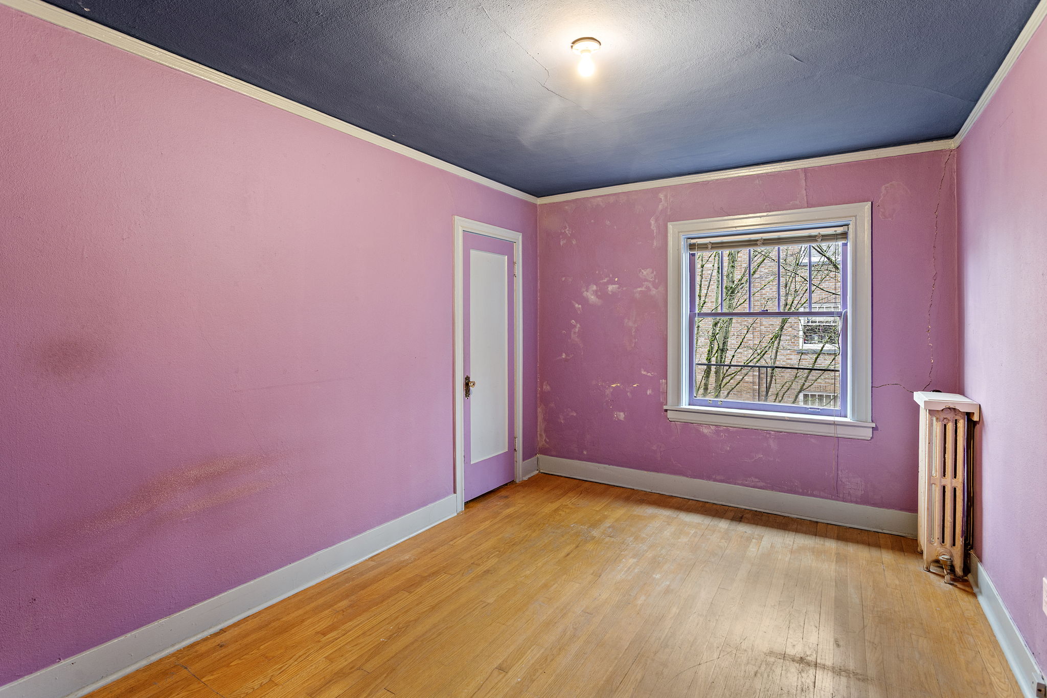 Wake up to courtyard views in this spacious bedroom—complete with a walk-in closet and ready for a bold refresh or your next color story.