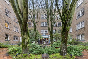 Tucked behind a wrought-iron gate, Garden Court’s central courtyard features brick paths, towering trees, and a fountain—an unexpected pocket of calm in the heart of Capitol Hill.