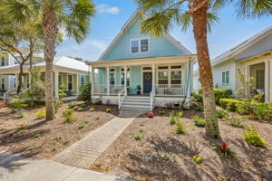 Soft coastal color, crisp architectural detail, and timeless curb appeal give the home its unmistakable charm.