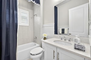 3rd full bath features floor to ceiling tile and there are even wood plaintation shutters there, also!