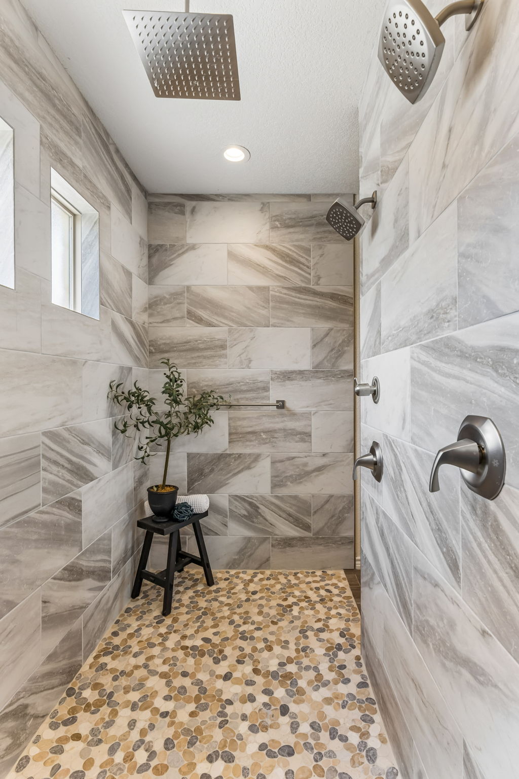 Walk-in shower with dual shower heads in the walk-in shower.