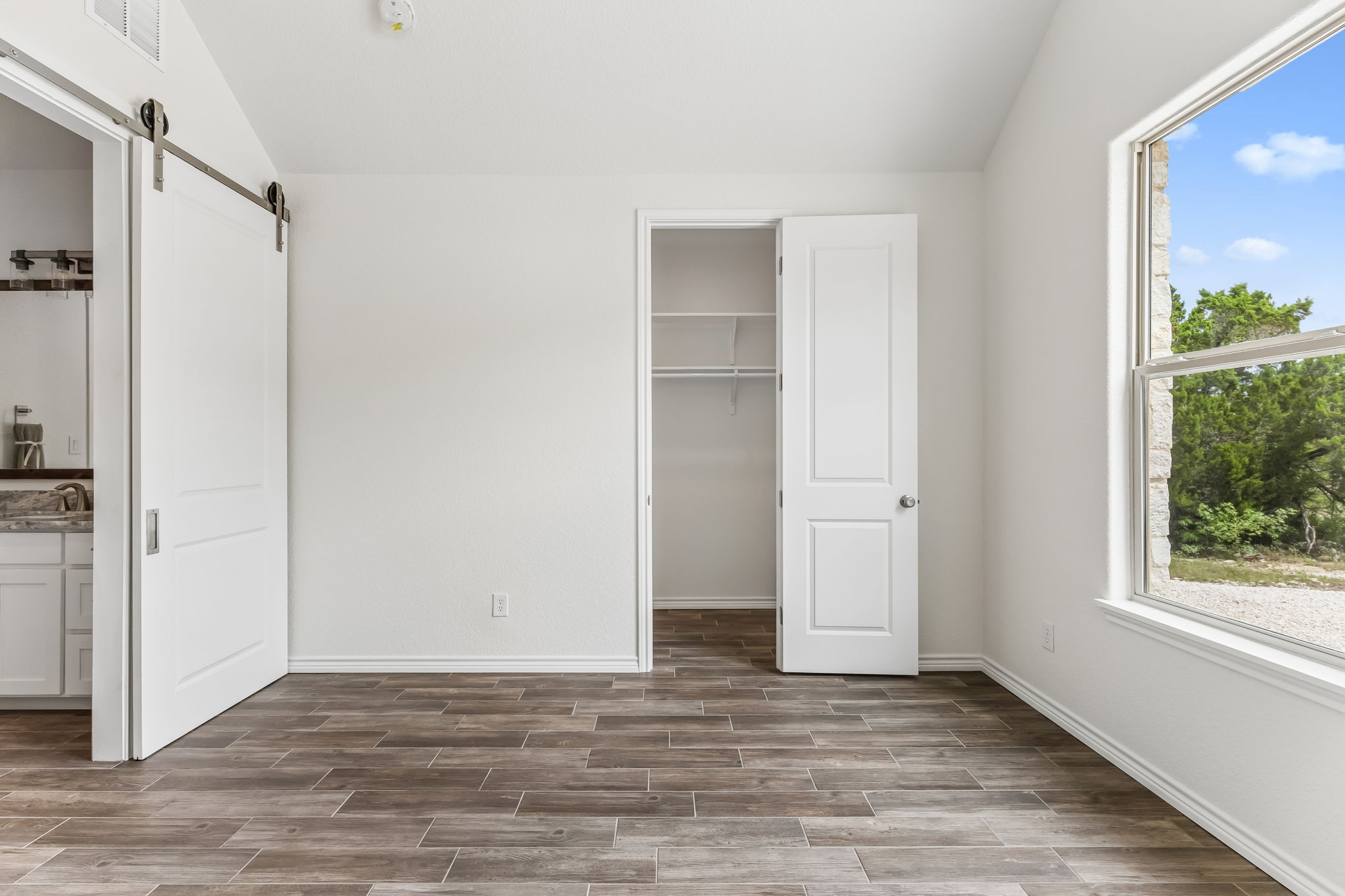 Home office/ or guest bedroom just down the hall from the primary suite. A barn door separates the bathroom.