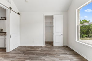 Home office/ or guest bedroom just down the hall from the primary suite. A barn door separates the bathroom.