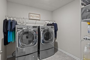Roomy laundry room with floor to ceiling storage shevling