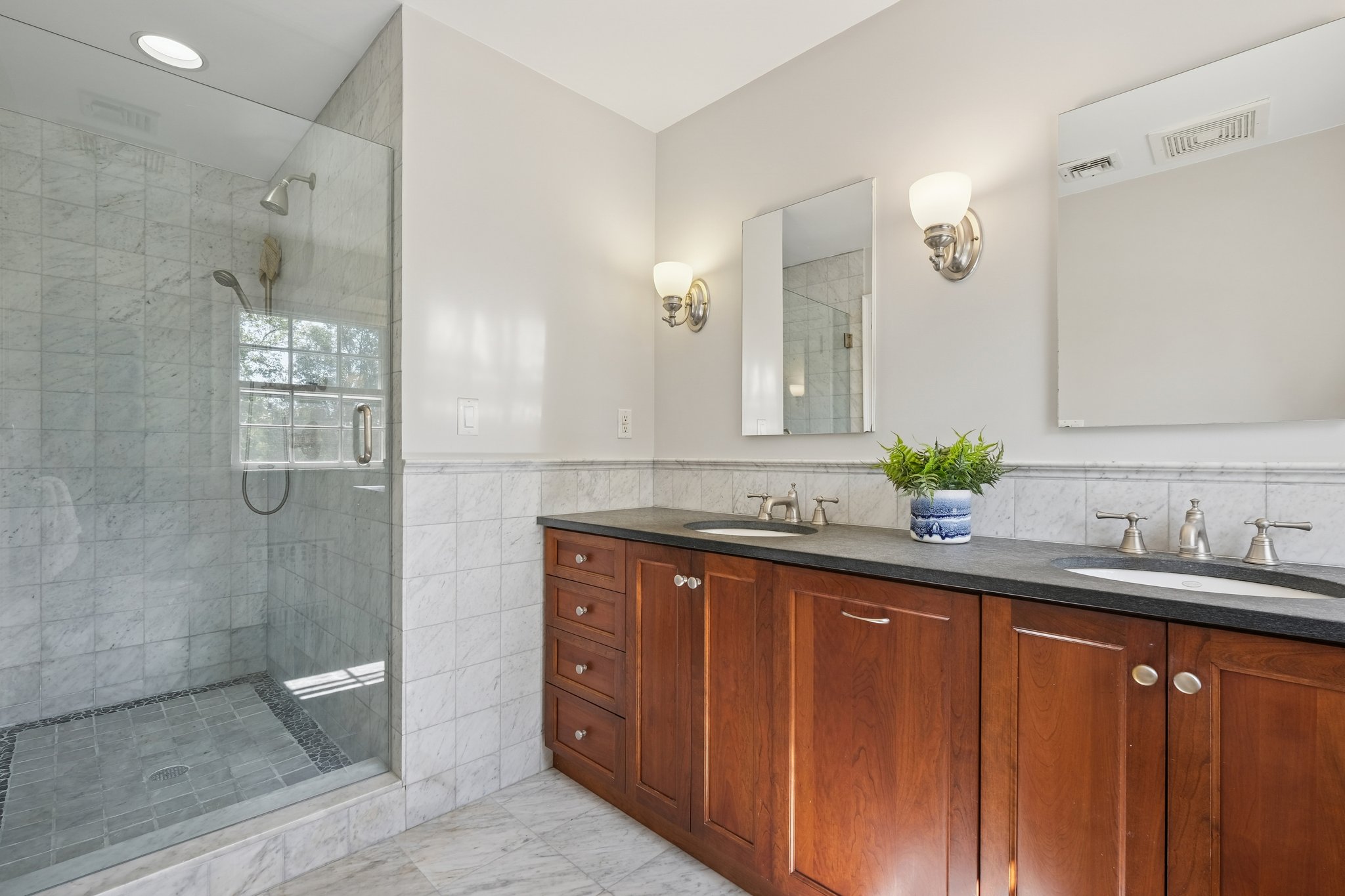 An updated primary bath with double sinks for harmony and a large stall shower that brings a little luxury to every day.