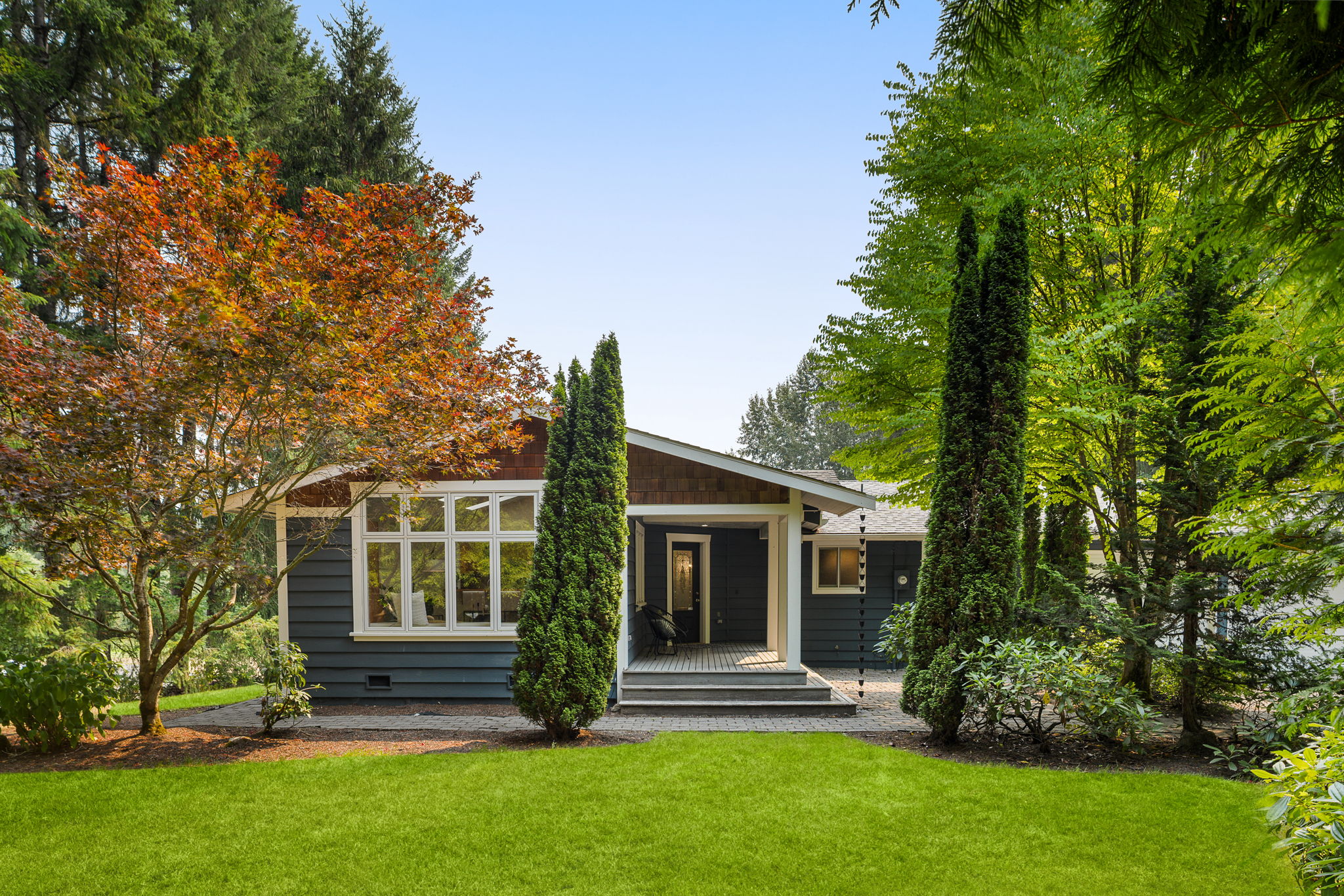 A welcoming arrival surrounded by mature Northwest landscaping.