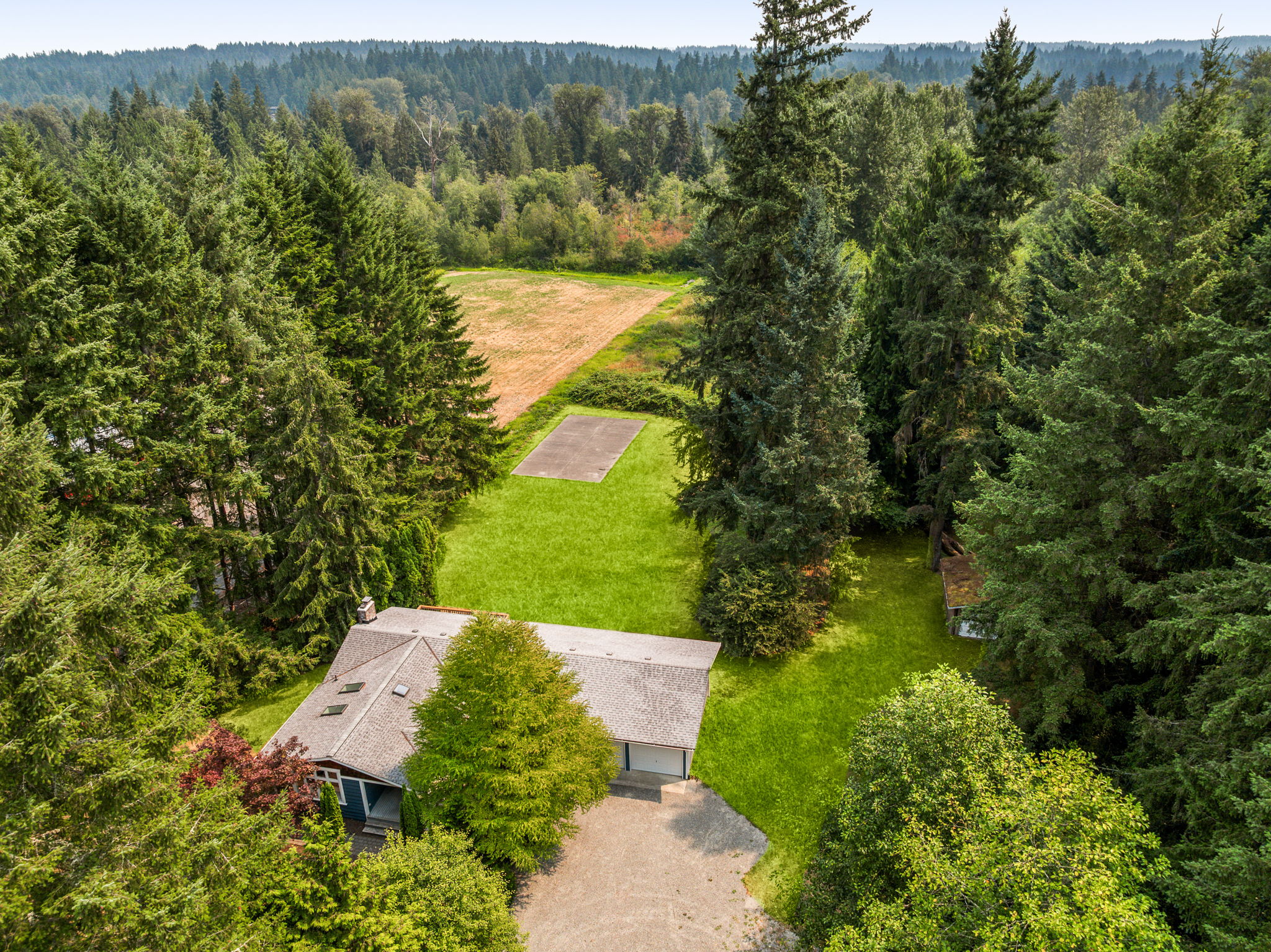 Outdoor living surrounded by nearly three private acres.