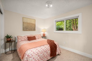 Main-level primary bedroom with peaceful wooded outlook.