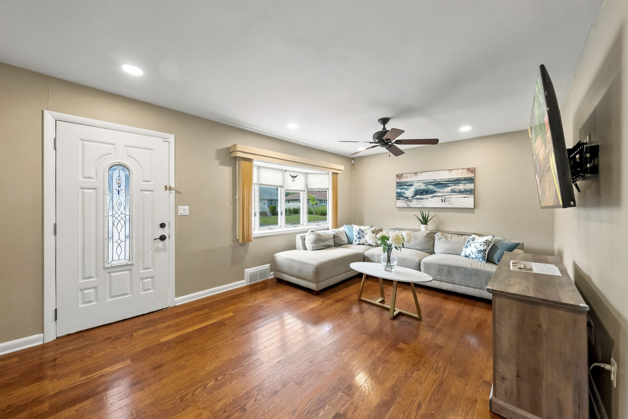 The light and bright living room features a wide front window, recessed lighting and hardwood floors that continue through most of the first floor.