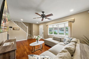 The light and bright living room features a wide front window, recessed lighting and hardwood floors that continue through most of the first floor.