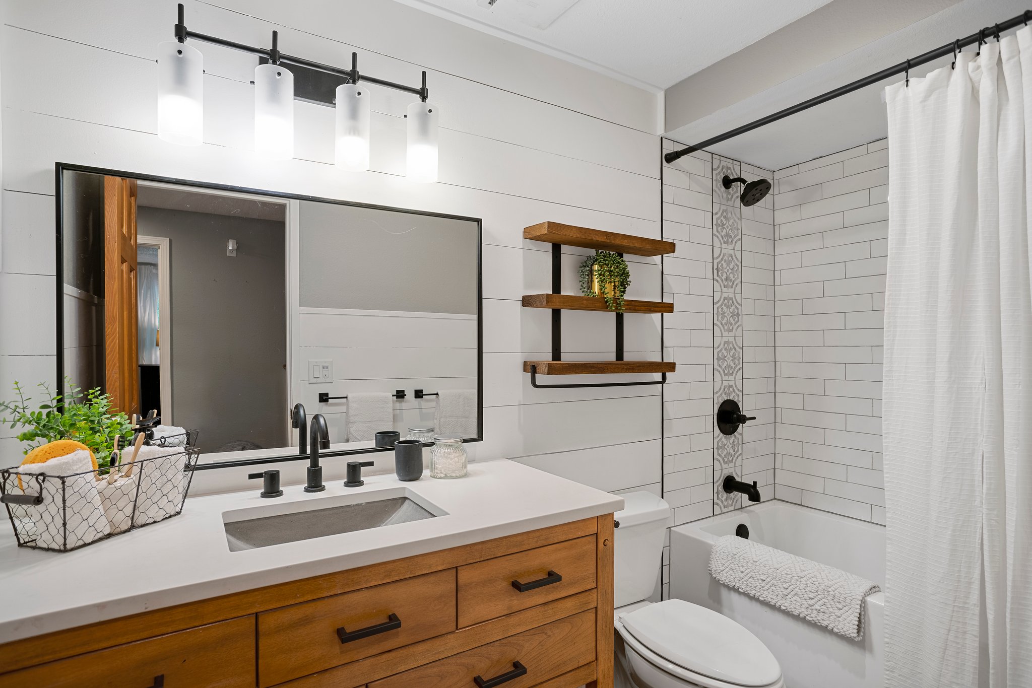 Remodeled upstairs bathroom. Subway tile shower, quartz countertop, and custom Board& Batten walls.