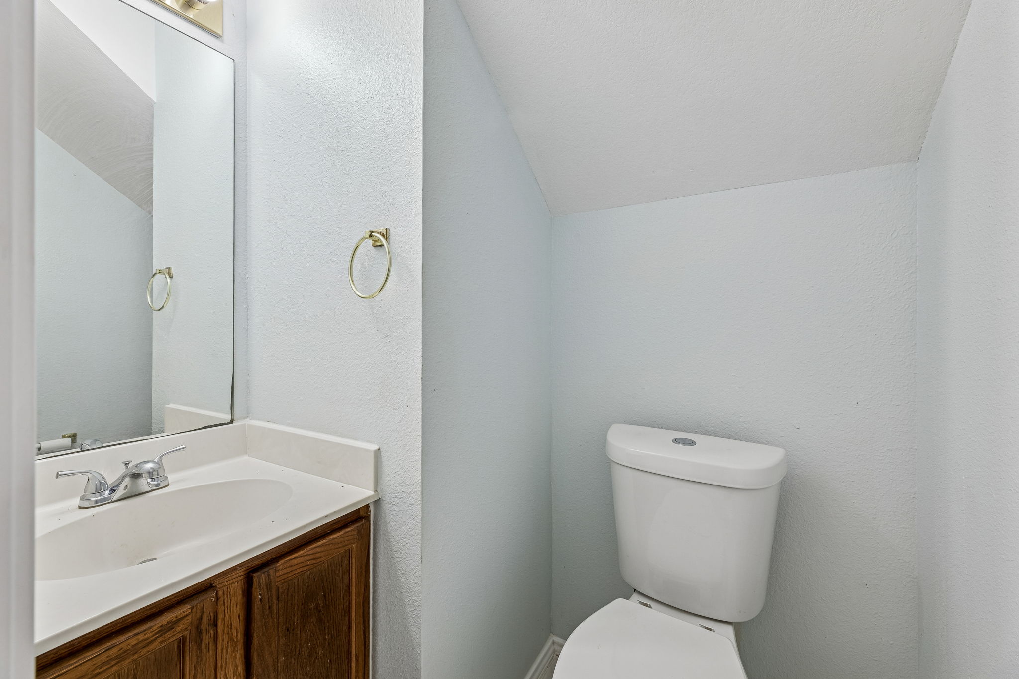 Half bathroom on the lower level near the door to the garage and across from the laundry room.