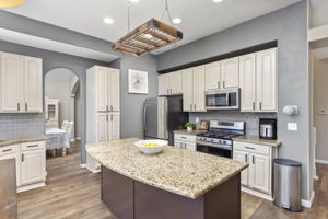 Upgraded kitchen. Custom-painted cabinets, granite counters, tile backsplash & stainless appliances. Breakfast island & nook. Gas range