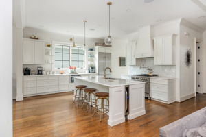 Open Kitchen with Large Island Including Custom Wine Fridge