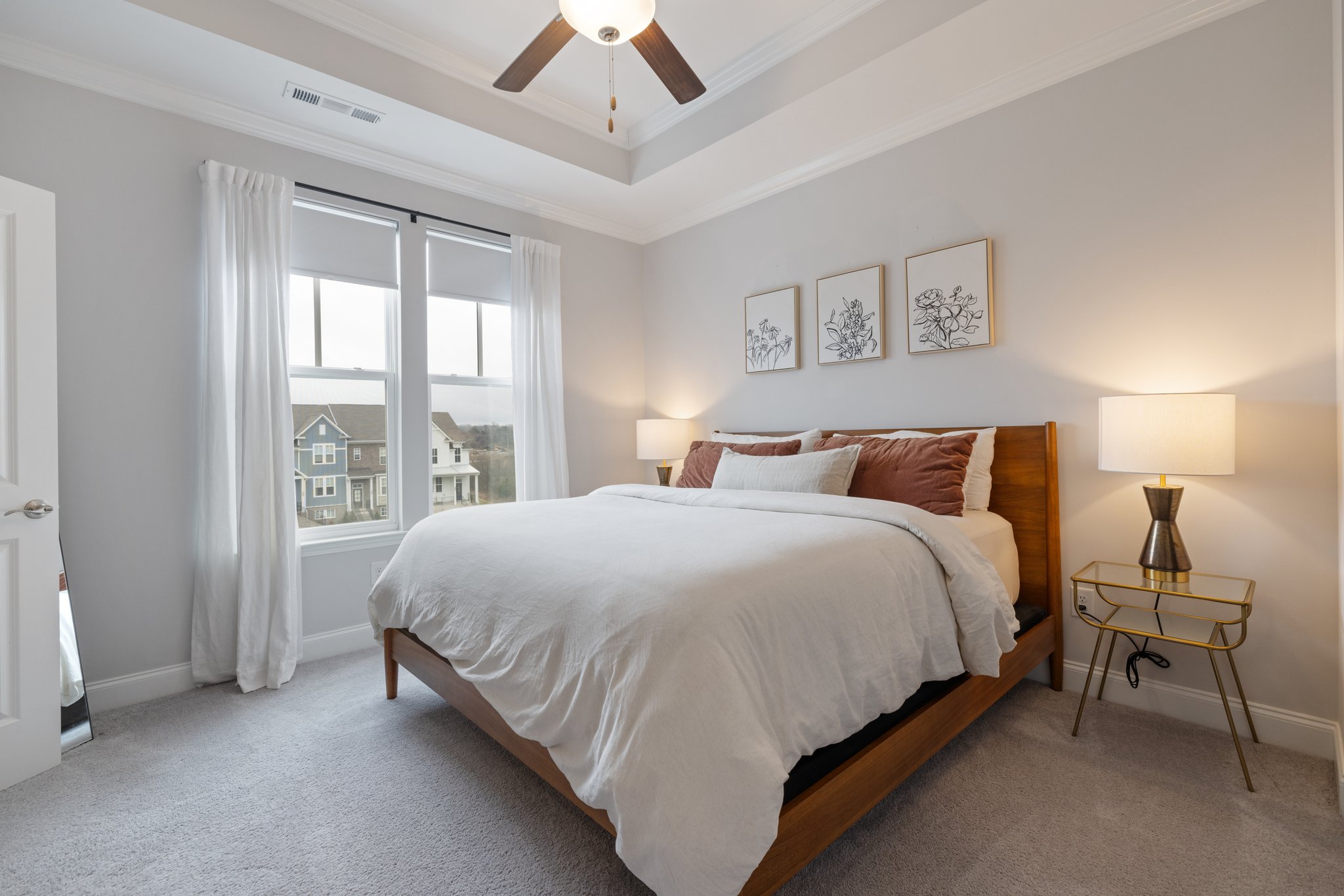 Beautiful primary bedroom with upgraded carpet, tray ceiling, walk in closet and large windows with custom blackout shades.