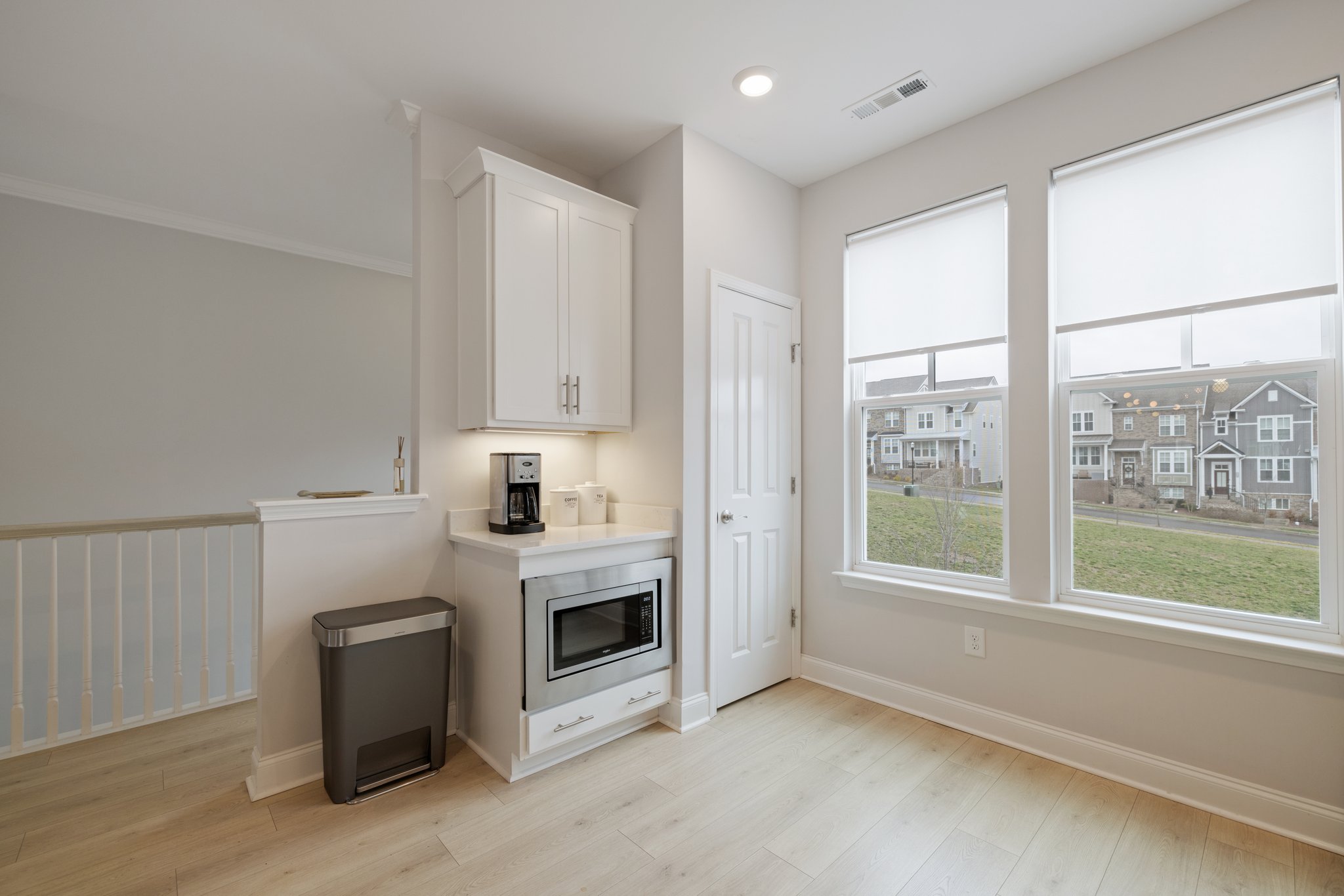 The kitchen boasts a large pantry and modern stainless appliances. Note the custom shades on every window!