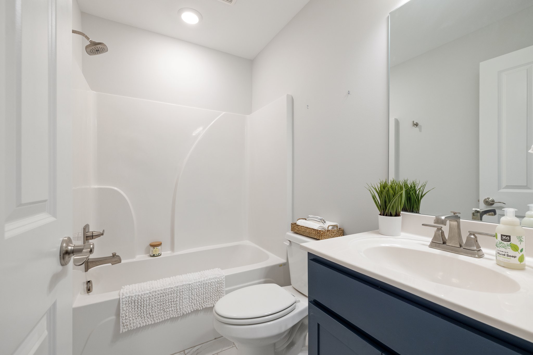 Full bathroom with shower/tub combo off the basement flex space.