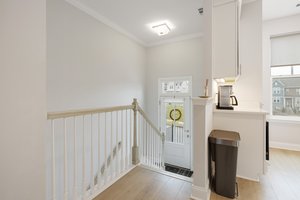 The entry foyer with stairs leading to the basement flex space.