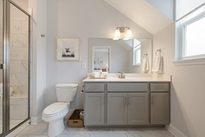 Primary bathroom featuring a walk-in shower with glass door and ceramic tile.