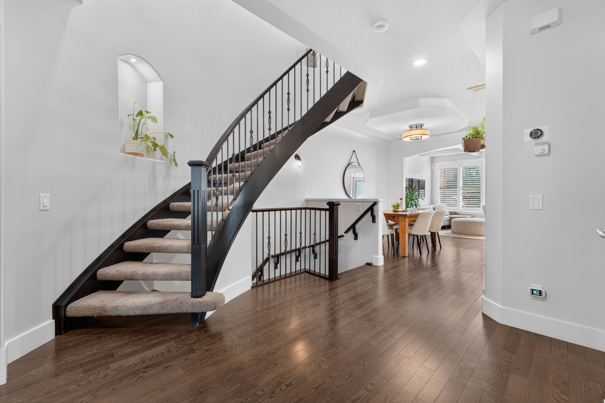 Curved staircase with a wrought-iron rail at the entry