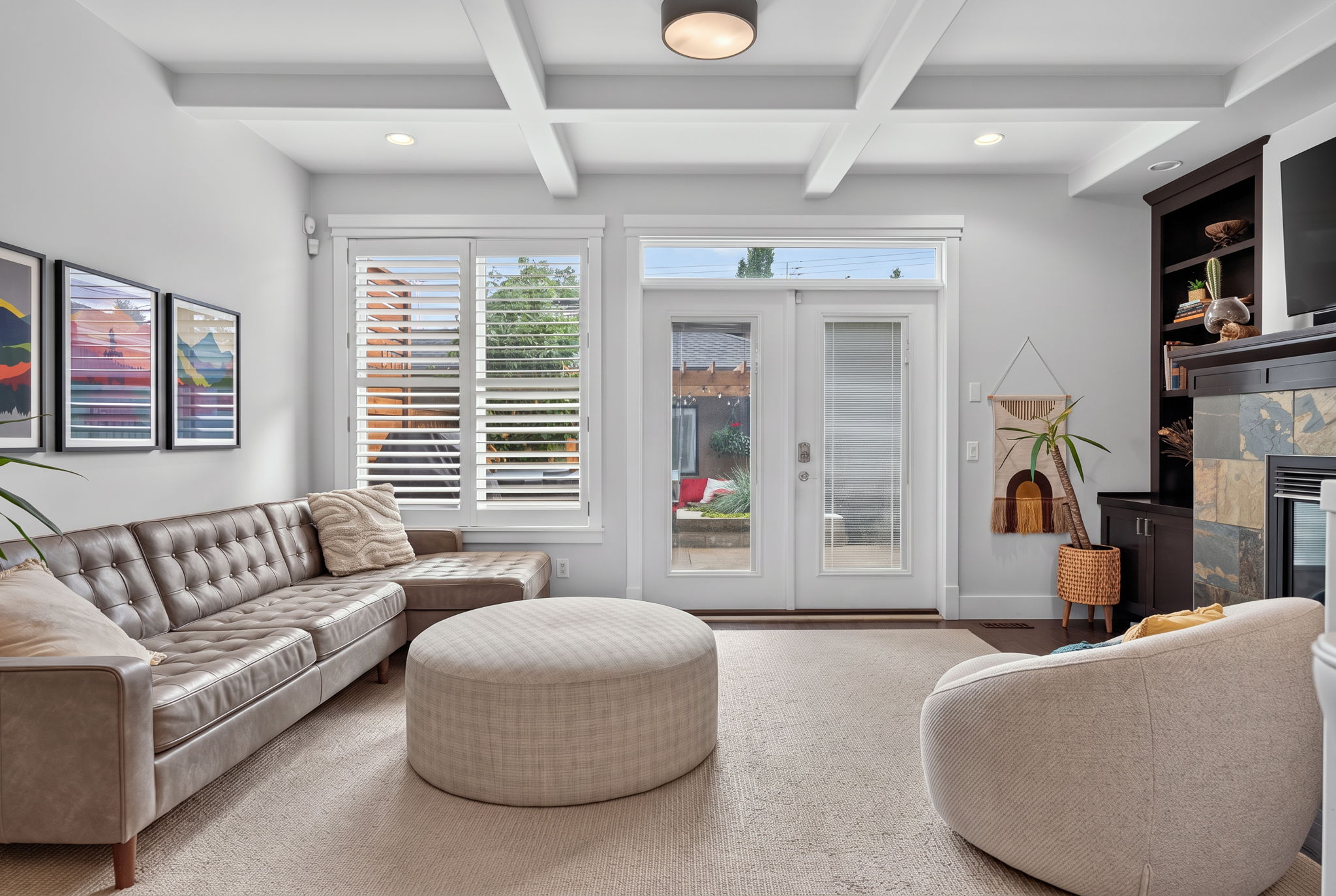 Living room under coffered ceilings with a slate-wrapped gas fireplace and built-ins
