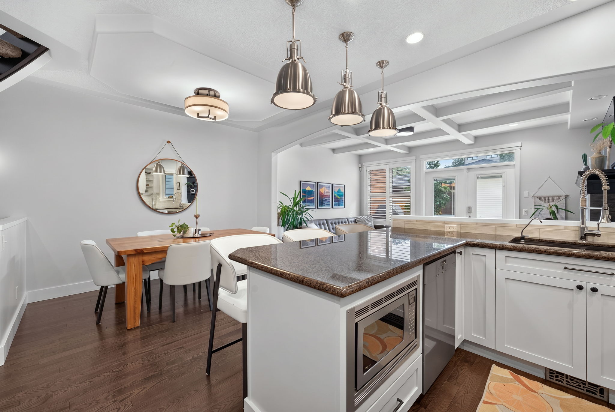 White kitchen with a granite island, gas range and stainless appliances